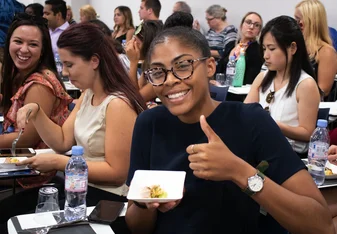 Female student of Forum-Nexus Study Abroad smiling and giving the thumbs up.
