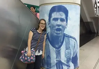 Image description: I am standing in a subway station with a massive image of Messi, the famous Argentina soccer player. 