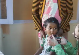 A child being given a vitamin during a routine check up!