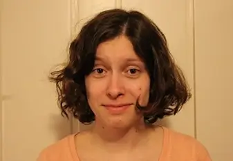 headshot of woman with brown hair and pink shirt