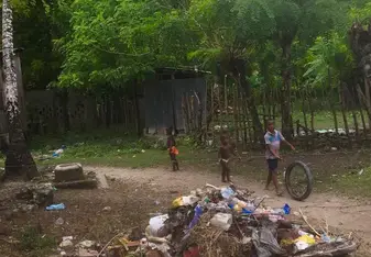 Dominican kids playing with a tire in the bateyes