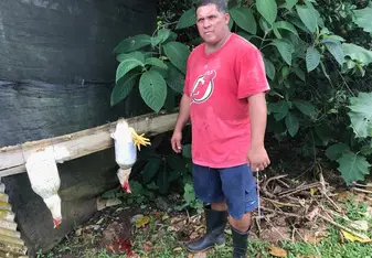 Elias homestay dad posing after slaughtering two chickens...