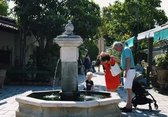A family discovers a fountain at L'Isle-sur-la-Sorgue