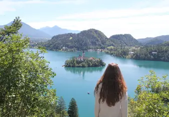 Photo of Lake Bled, Slovenia. In the centre of the lake sits an island with a church on it.