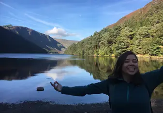 A girl smiling in front of a lake