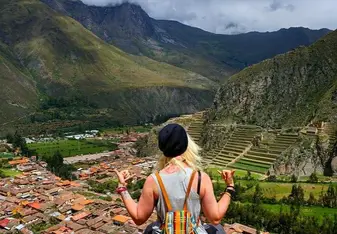 Me sitting off the edge of a cliff looking over the city of Ollantaytambo.