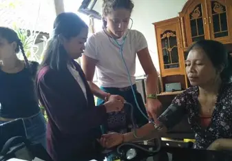 This is a picture of me taking the heart rate of a local woman in her home.