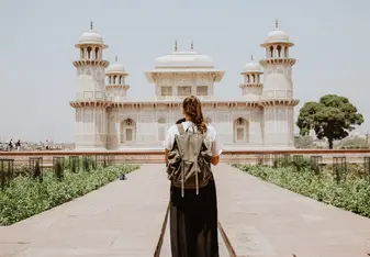 Young woman's back in front of historic Indian building