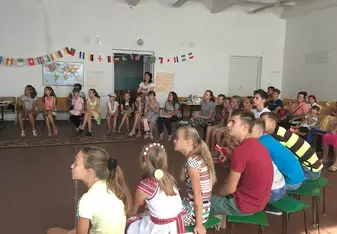 30 youth sitting in a gymnasium watching a slideshow
