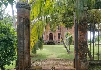 Looking through a broken gate into the primary courtyard and prison ruins on Ile Royale, largest of the Salvation's Islands, infamous French prison from 1852 to 1953.