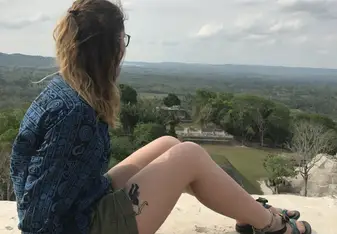 Girl overlooking Mayan ruins.