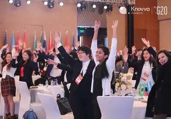 Students wave at aModel G20 Youth Leadership Summit