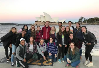 Students striking a pose in front of the famous Sydney Opera House.