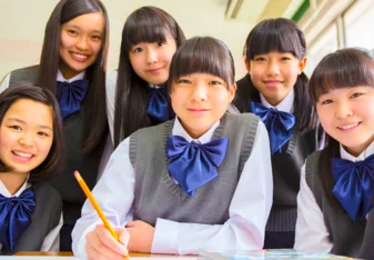 group of students wearing school uniforms with blue bows
