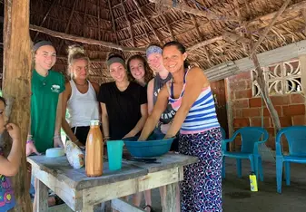 Volunteers learning how to make cheese from local mother, Sara