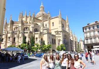 Group of girls in front of an intricate Basilica in Segovia