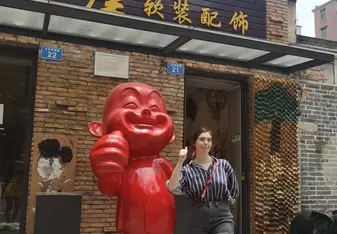 Young woman posing with statue in China