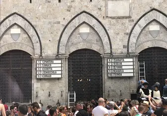 Before Palio, more than one hundred horses are brought to Siena and tested around the Palio course. Finally, ten are selected to run. The horses are assigned to the contrade at random, by a drawing. This is the board where the horses are paired with their contrada, for the July 2019 Palio race.