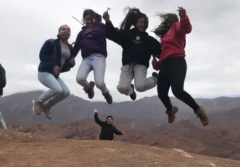 We hiked up a mountain and did a jump shot on top of a mountain, while one of our group leaders does a funny pose. 