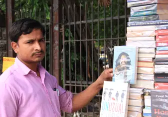 A local bookseller posing with Michelle Obama's novel.