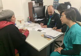 I am speaking with a patient in Spanish so that I can translate her problems to the American doctor