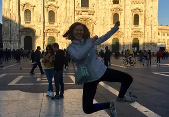 A student is photographed jumping in the Piazza del Duomo with the famous cathedral in the background.