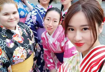 6 people posing at a shrine in very colorful winter kimono's