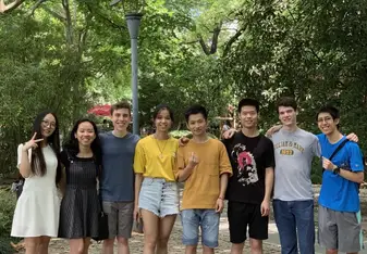 A group of friends in a park, smiling at the camera. 