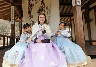 3 girls dressed in hanbok, traditional Korean clothes, sending hearts to the camera