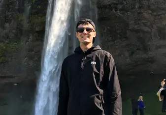 Visiting a beautiful waterfall during a sunny day.