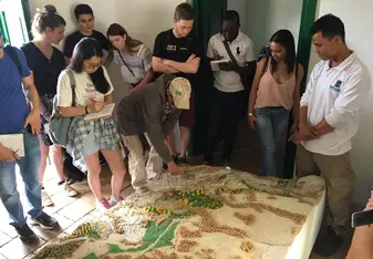 Group receiving a talk over a large landscape model