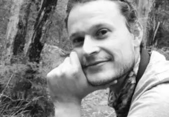 black and white image of man in wooded area
