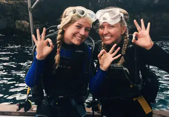 two girls smiling in galapagos about to go scuba diving
