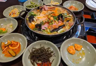 picture of a seafood soup with side dishes