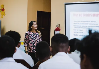 Intern participant facilitating awareness presentations to local students 