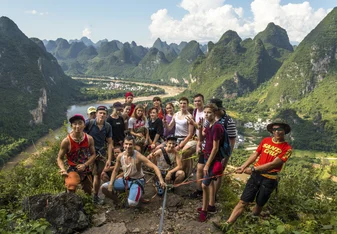A group photos of students backdropped by Yangshuo landscape