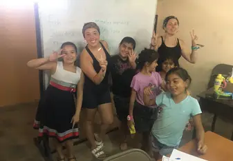 Standing in front of the white board in our classroom with my assistant teacher and 5 of our students holding up peace signs and being silly on the last day of class. 