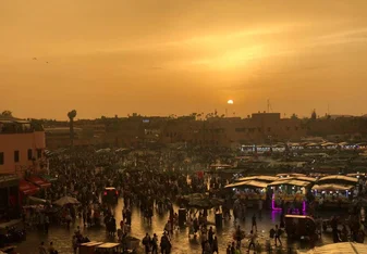 Eating dinner overlooking the Marrakech marketplace as the sun sets. 