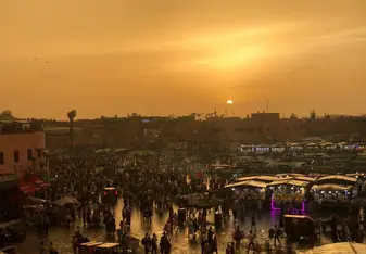 Eating dinner overlooking the Marrakech marketplace as the sun sets. 