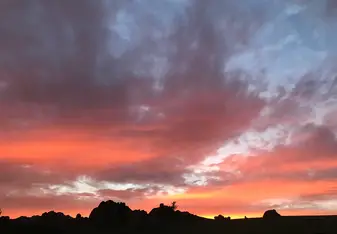 The most beautiful sunset ever seen with a mountain range shadowed over.