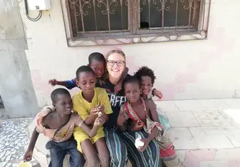 A picture of me and a few kids while they were enjoying the breakfast they got from Projects Abroad.