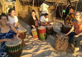 A group of volunteers learning how to play drums.