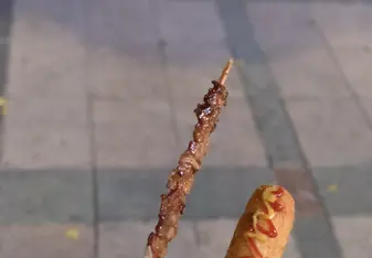 A Korean corn dog and meat skewer. They can be found and bought on the street by vendors.
