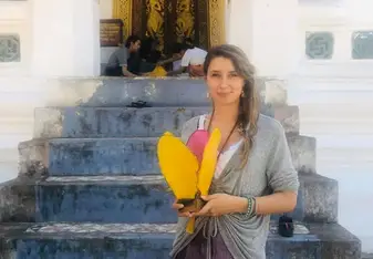 Standing outside of a temple with a handmade lantern.