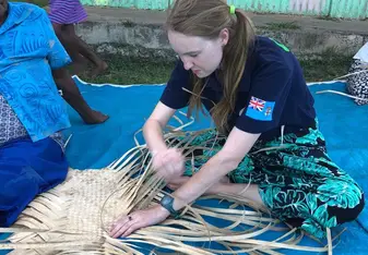 Zoe is weaving a traditional Fijian mat while Mere supervises