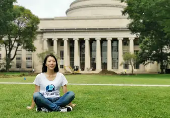 Candy sitting in the grass in front of MIT.