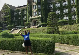 Girl in front of ivy covered school building at Yonsei Univerity
