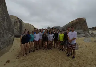 students standing in group on beach 