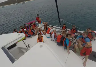students gathered on front of one of the boats used for program