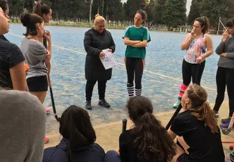 My field hockey team gathers around our coach to discuss a play
